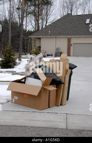 Weekly trash sit on the curb of a residential home waiting to be picked up by garbage collectors Stock Photo