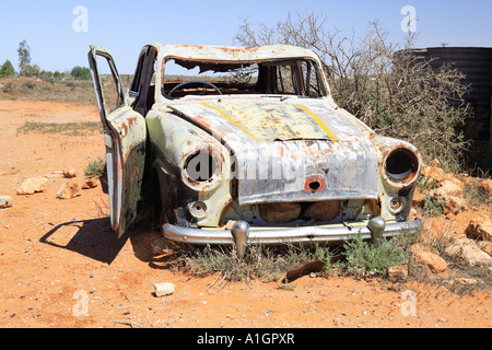 Derelict car next to old water tank ruins Silverton near Broken Hill New South Wales Australia Stock Photo