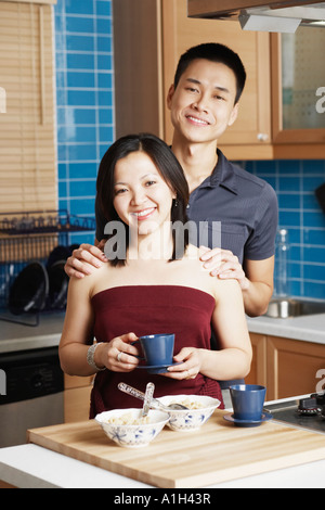 Portrait of a young woman standing with a young man holding a tea cup Stock Photo
