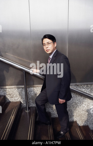 Portrait of a businessman walking up a staircase Stock Photo
