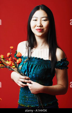 Portrait of a young woman holding a bunch of flowers Stock Photo