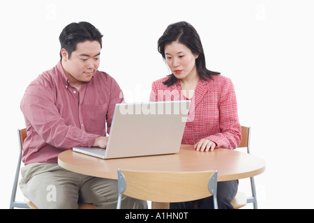 Close-up of a businessman and a businesswoman using a laptop Stock Photo