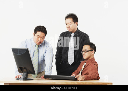 Three businessmen looking at a computer monitor Stock Photo