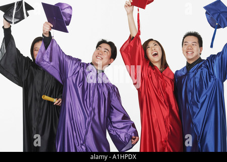 Two male graduates and two female graduates holding their mortar boards Stock Photo