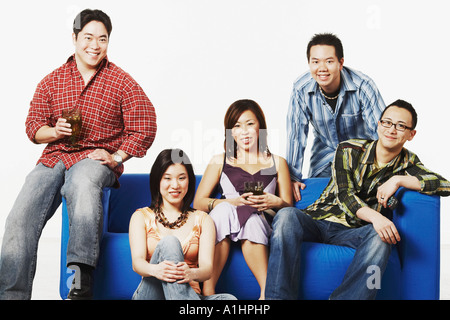 Portrait of two young women and three young men smiling Stock Photo