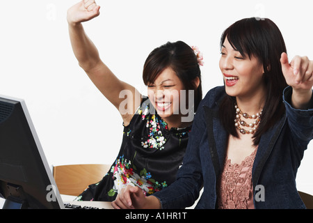 Close-up of two businesswomen smiling with their hands raised Stock Photo