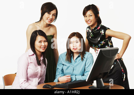 Portrait of four businesswomen smiling in front of a computer Stock Photo