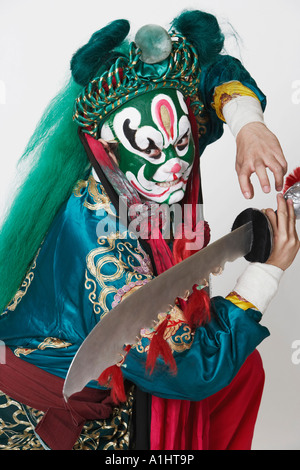 Side profile of a male Chinese opera performer holding a weapon Stock Photo