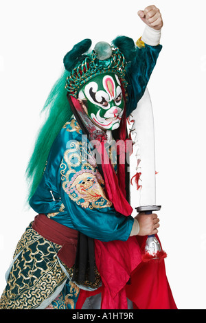 Side profile of a male Chinese opera performer holding a weapon Stock Photo