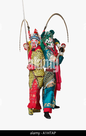 Side profile of two male Chinese opera performers gesturing with weapons Stock Photo