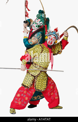 Two male Chinese opera performers gesturing with weapons Stock Photo