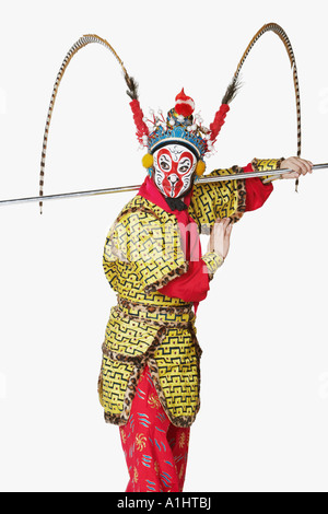 Side profile of a male Chinese opera performer gesturing with a weapon Stock Photo