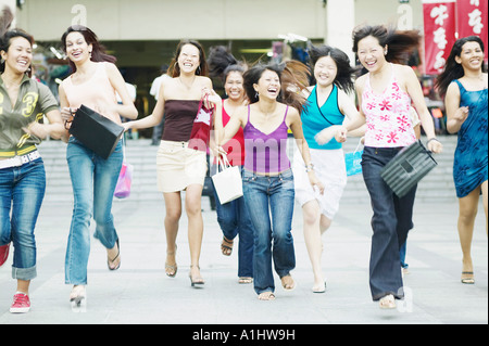 Group of young women running with shopping bags Stock Photo