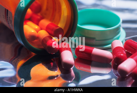 Pills spilling out of open container. Capsules meds, prescription medication. Close-up or close up dose of drugs for medical treatment. Pill bottle. Stock Photo