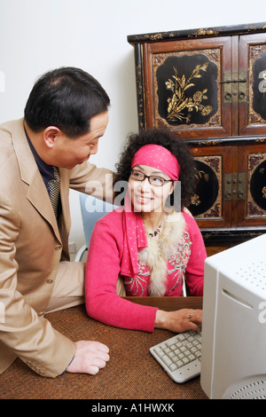Close-up of a businesswoman using a computer with a businessman sitting beside her Stock Photo