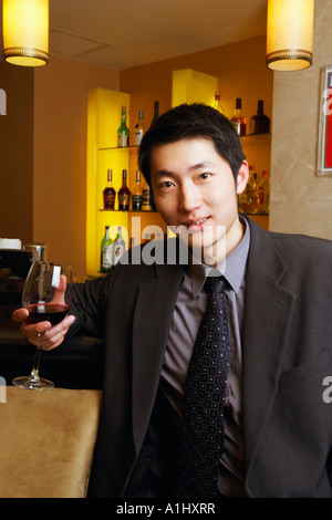 Portrait of a young man holding a glass of red wine Stock Photo