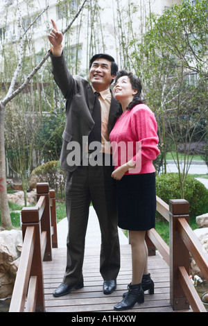 Mature man pointing to a mature woman smiling Stock Photo