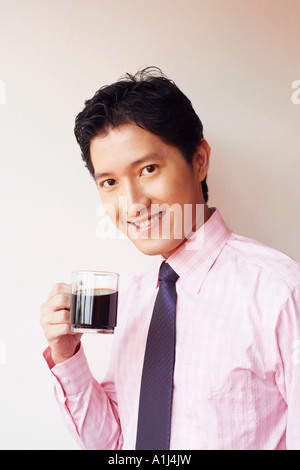 Portrait of a businessman drinking a cup of black tea and smiling Stock Photo