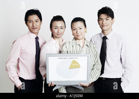 Portrait of two businesswomen with two businessmen holding a progress report and smiling Stock Photo