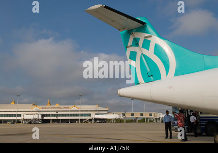 Mandalay International Airport. A man takes a photograph of  his friend, an Air Bagan aircraft Myanmar  2006 Stock Photo