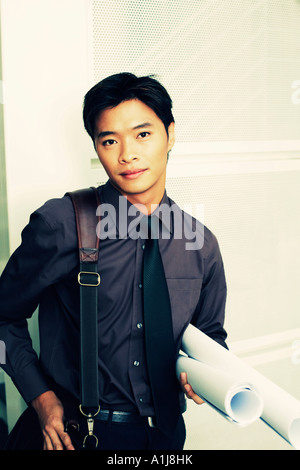 Portrait of a male architect holding rolled up blueprints Stock Photo