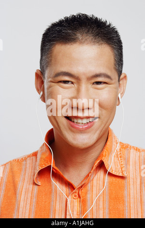 Portrait of a mid adult man wearing headphones and listening to music Stock Photo