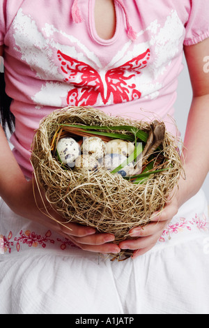 Mid section view of a girl holding eggs in a bird's nest Stock Photo