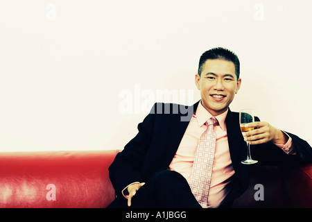 Portrait of a businessman holding a champagne flute and smiling Stock Photo