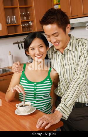 Portrait of a young couple smiling at a kitchen counter Stock Photo