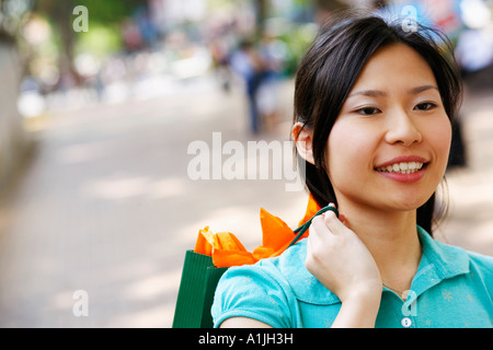 Close-up of a young woman carrying a shopping bag Stock Photo