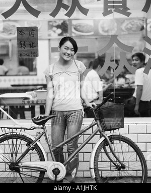 Portrait of a teenage girl standing with her bicycle in front of a restaurant Portrait of a teenage girl standing with her bicycle in front of a restaurant