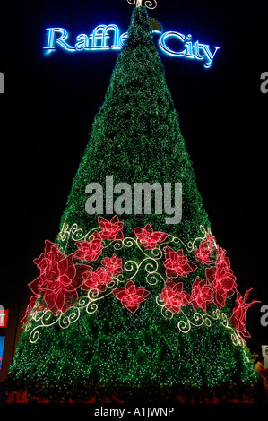 Christmas tree and Orchid garland in Singapore outside the Raffles City shopping centre. Stock Photo