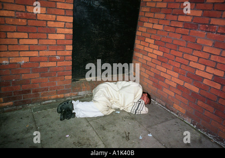 Homeless person sleeping rough on the pavement in London. Stock Photo