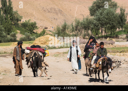 AFGHANISTAN between Chakhcharan and Jam Pal Kotal i Guk Aimaq people walking and riding donkeys enter village Stock Photo