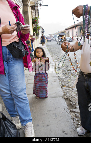 GUATEMALA ANTIGUA Young Cakchiquel girl in traditional dress begging from tourists on the street Stock Photo