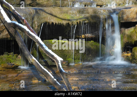 Small waterfall in a crystal clear stream on a winter morning Stock Photo