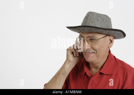 Senior citizen wearing hat talking on mobile phone Stock Photo