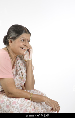Indian senior citizen with dot on forehead in sari talking on cellphone Stock Photo