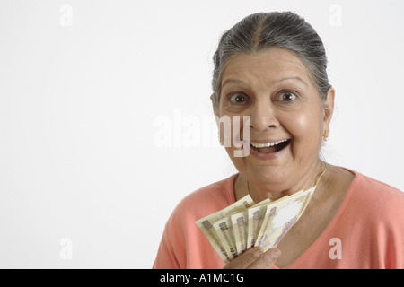 Happy Indian senior citizen with paper money Rupees in hand Stock Photo