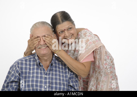 Indian old senior couple playing, wife hands on eyes of husband Stock Photo