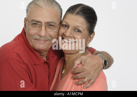 Indian senior citizen couple embracing on white background Stock Photo