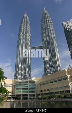 The Petronas twin towers set against a perfect blue sky and lush green park in Kuala Lumpur Malaysia Asia Stock Photo