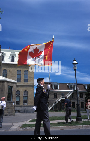 D Day Invasion Memorial parade in Fredericton New Brunswick Canada with one soldier carrying the Canadian Flag Stock Photo