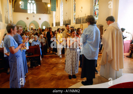 St Joseph's Church Person Receiving Communion & Queuing People  Roehampton Stock Photo