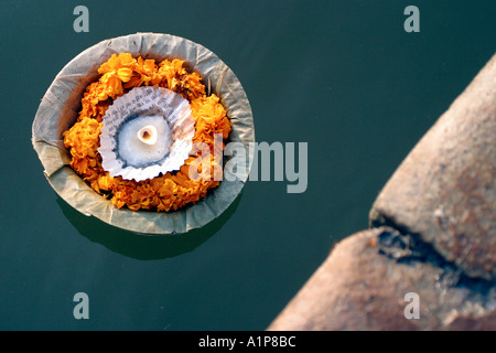 A lit candle floats in the water of the holy river Ganges in Varanasi in northern India Stock Photo