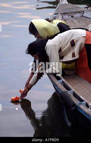 Two girls put a lit candle on the holy river Ganges in Varanasi in northern India Stock Photo