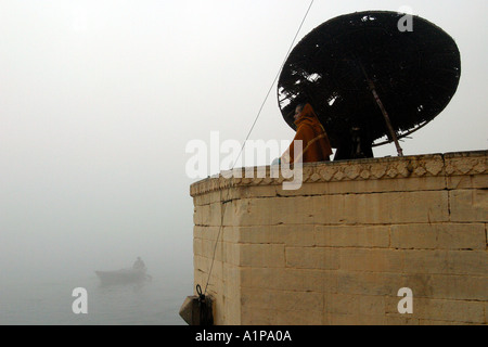 A man meditates on the bank of the holy river Ganges in the city of Varanasi in northern India Stock Photo