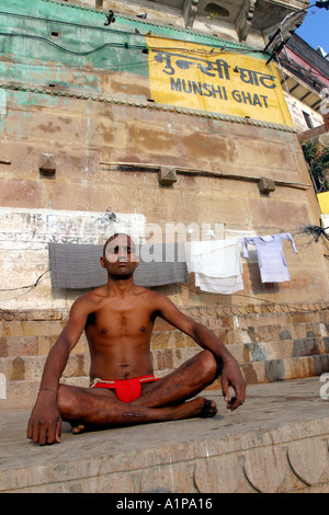 A man meditates on the bank of the holy river Ganges in the city of Varanasi in northern India Stock Photo