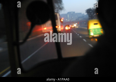 A view from inside an auto-rickshaw driving on a road in New Delhi in India. Stock Photo