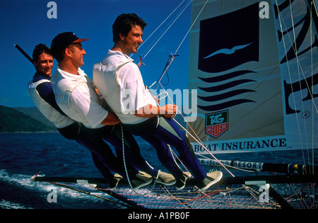 Crew of three on trapeze 18 foot skiff racing at Hayman Island Queensland Australia Stock Photo